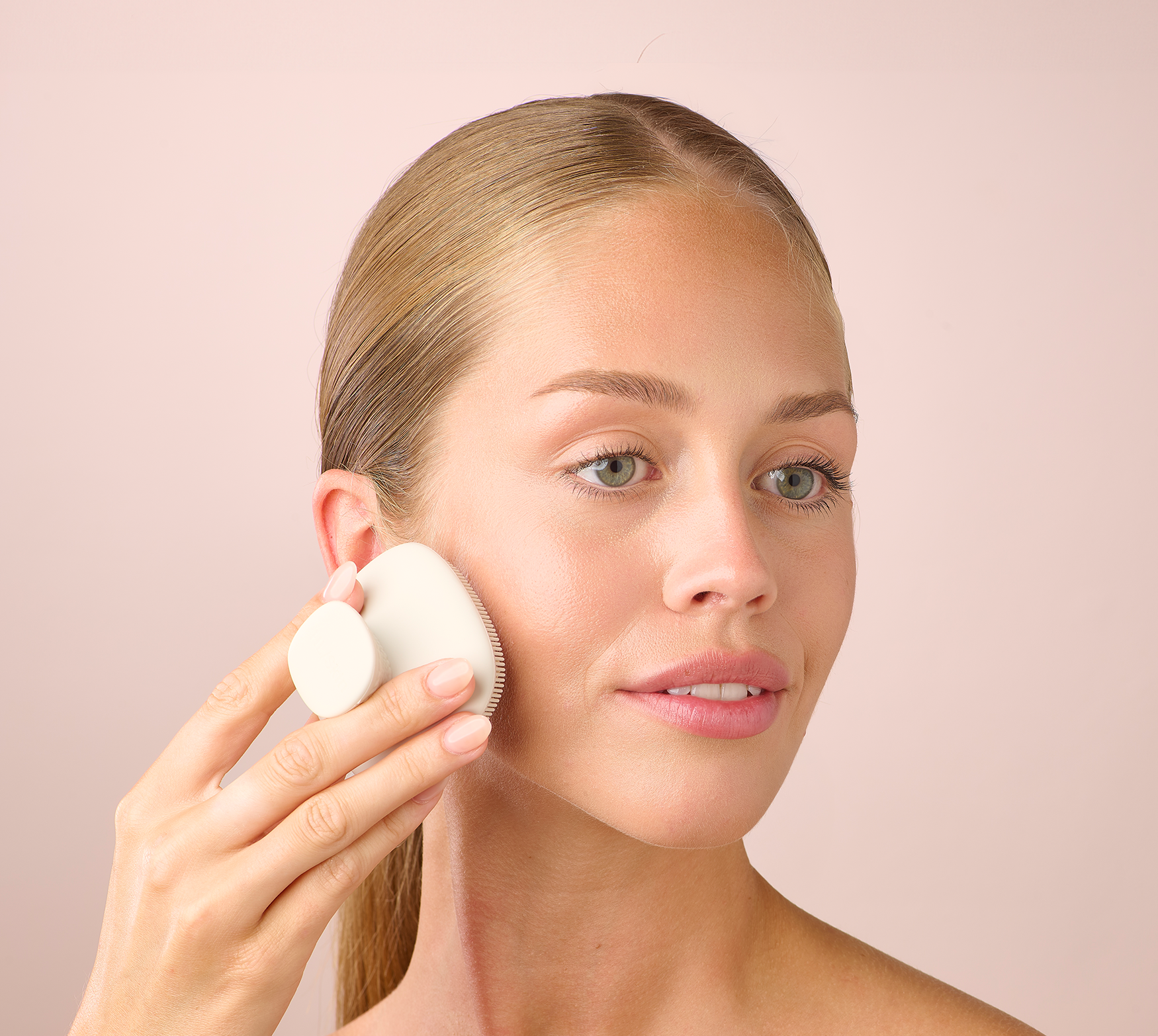 A woman using a HL/Skin Cleansing Silicone Brush